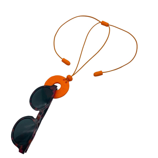 Orange Polymer clay necklace and glasses holder holding sunglasses with on a white background